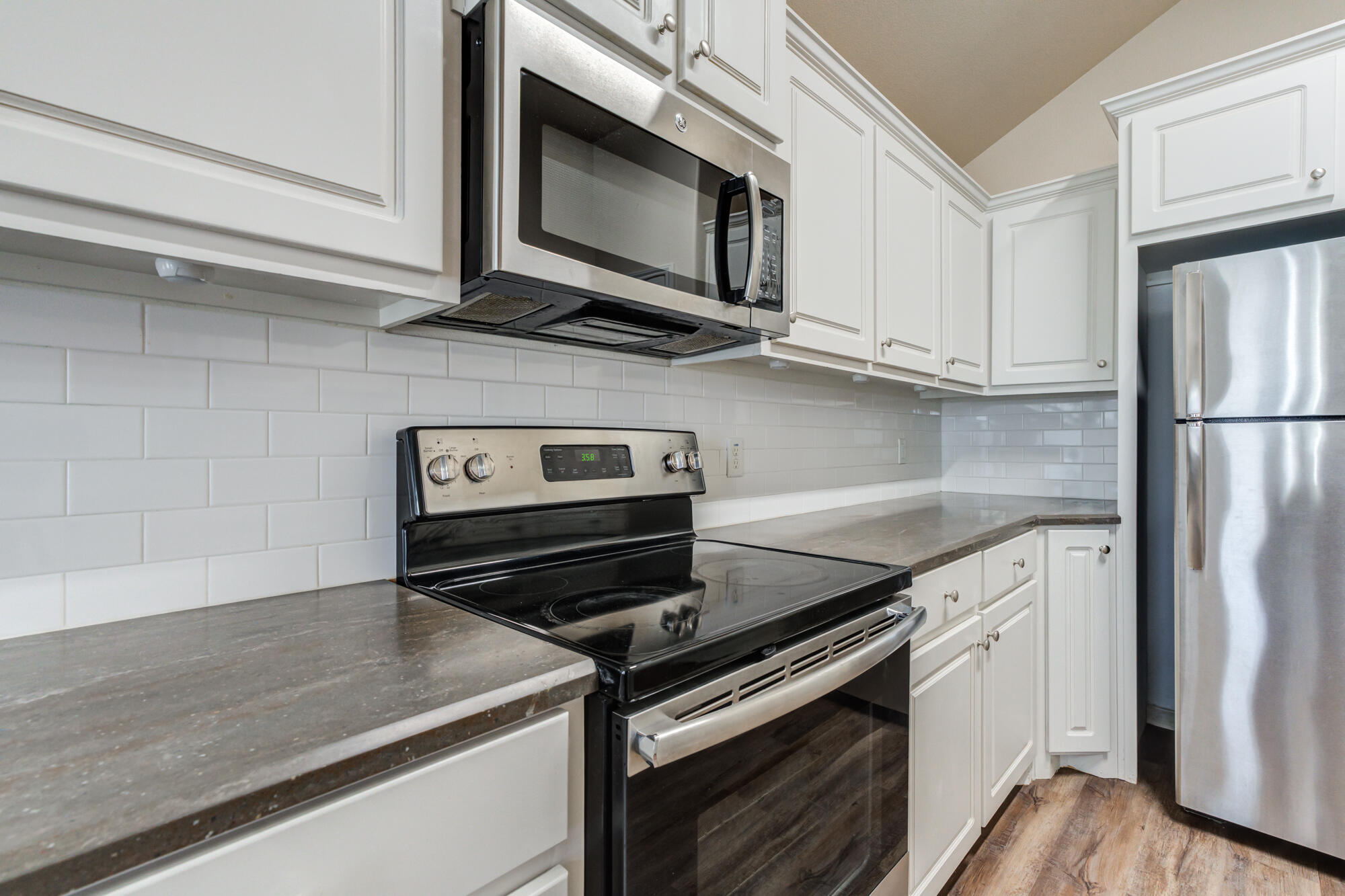 7518 87th Street Lubbock, TX 79424 - Photo 18 of 36 a kitchen with stainless steel appliances granite countertop a stove and a microwave
