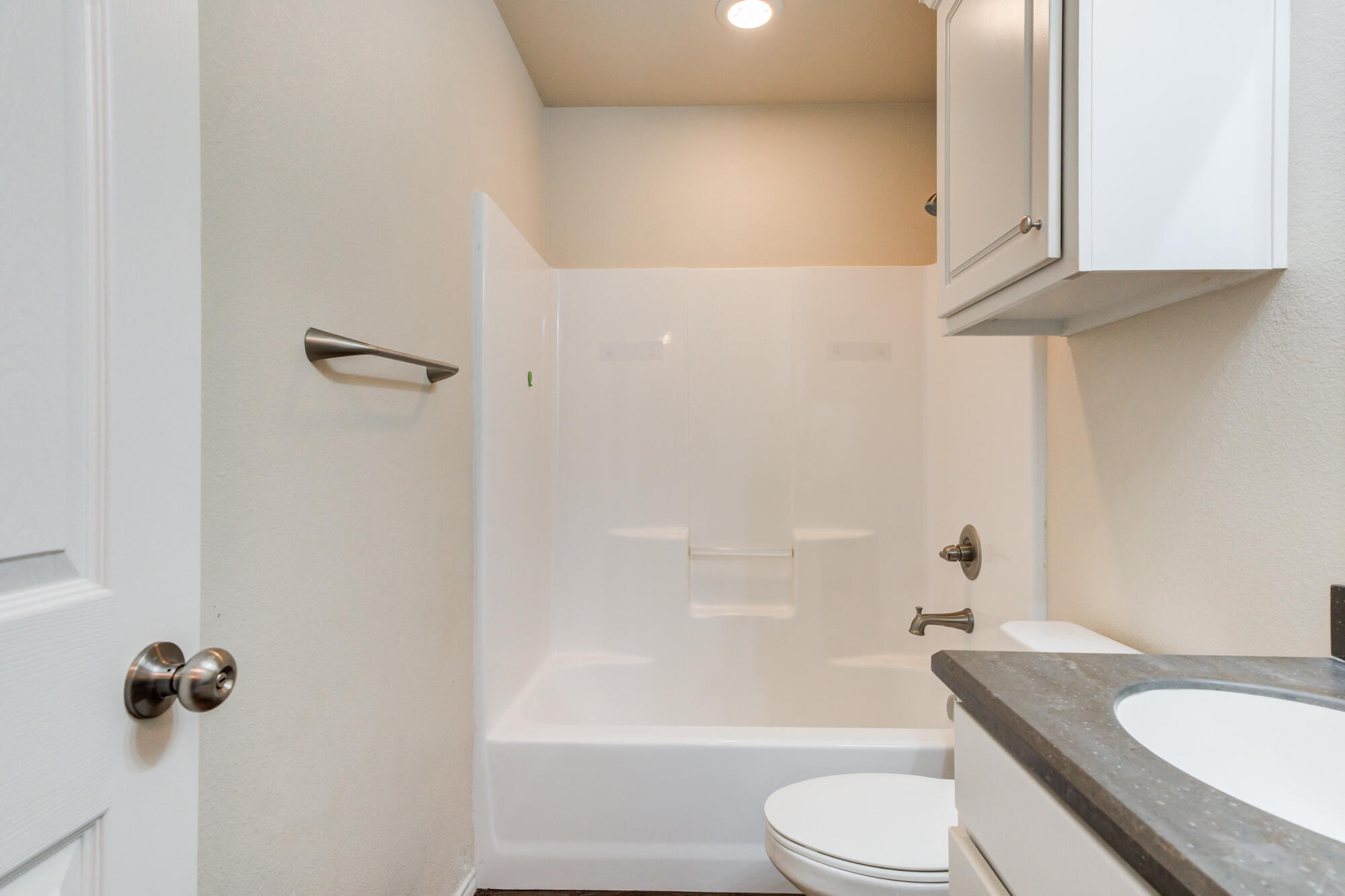 7518 87th Street Lubbock, TX 79424 - Photo 22 of 36 a bathroom with a granite countertop bathtub toilet and sink
