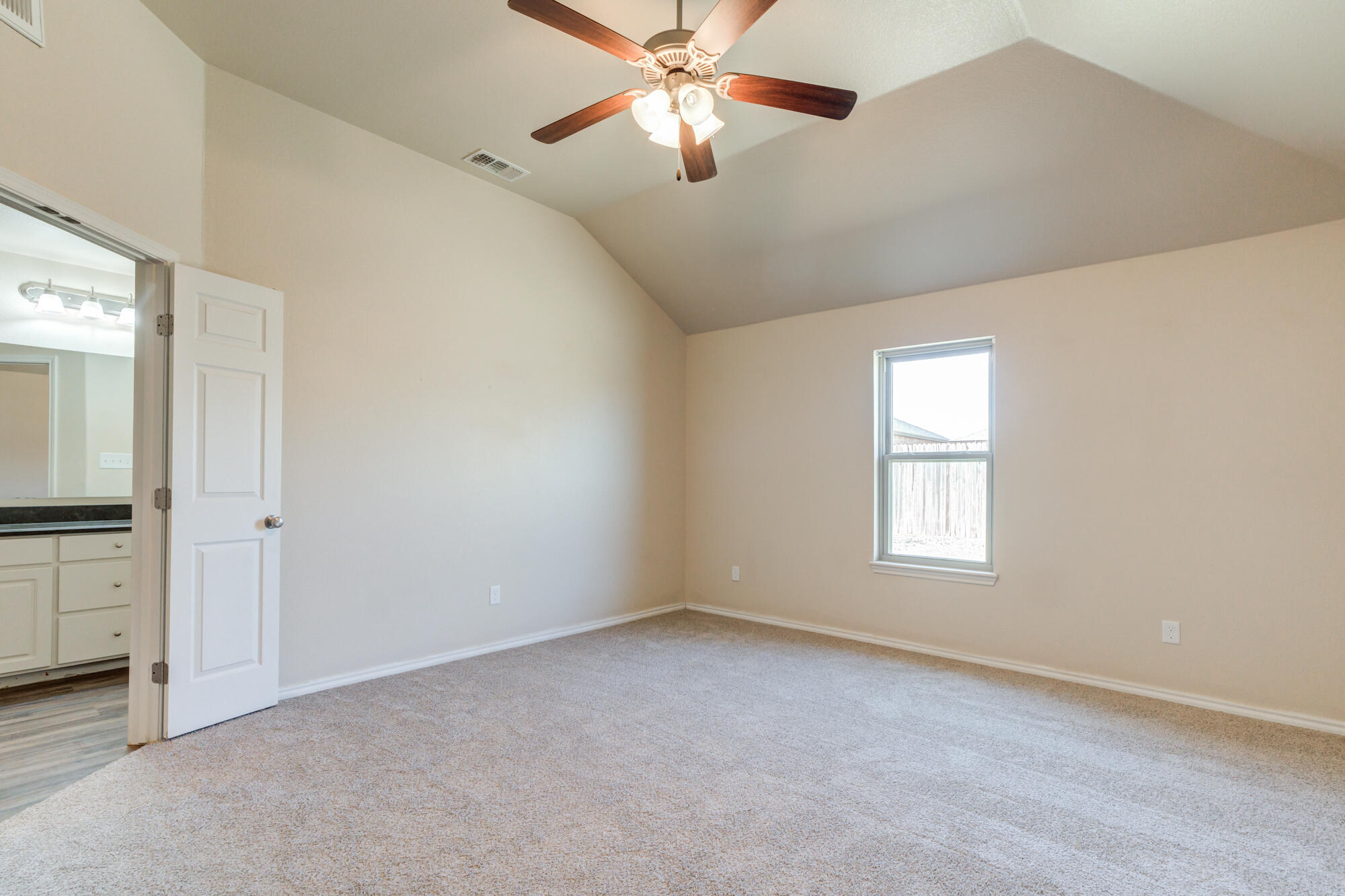 7518 87th Street Lubbock, TX 79424 - Photo 25 of 36 a view of an empty room with chandelier fan and a window