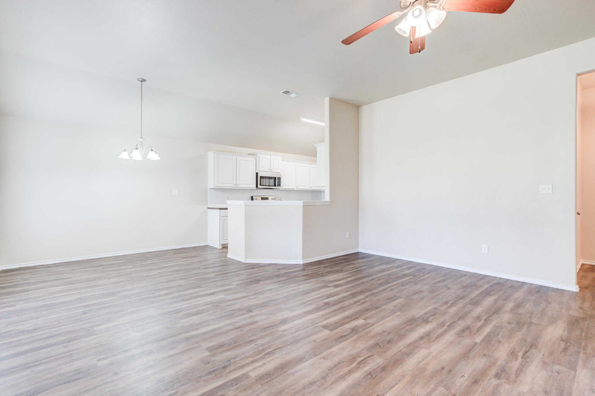 7518 87th Street Lubbock, TX 79424 - Photo 5 of 36 a view of a kitchen with a dishwasher cabinets and wooden floor