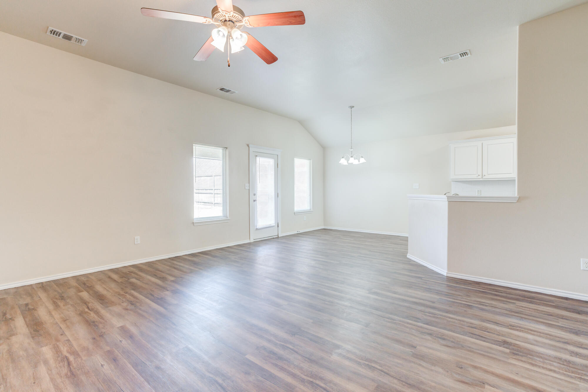 7518 87th Street Lubbock, TX 79424 - Photo 7 of 36 wooden floor in an empty room with a window