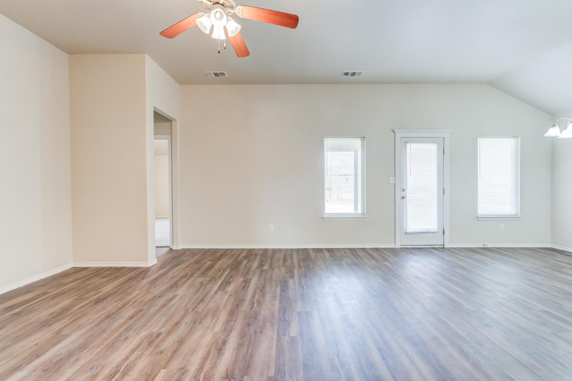 7518 87th Street Lubbock, TX 79424 - Photo 8 of 36 an empty room with wooden floor and windows