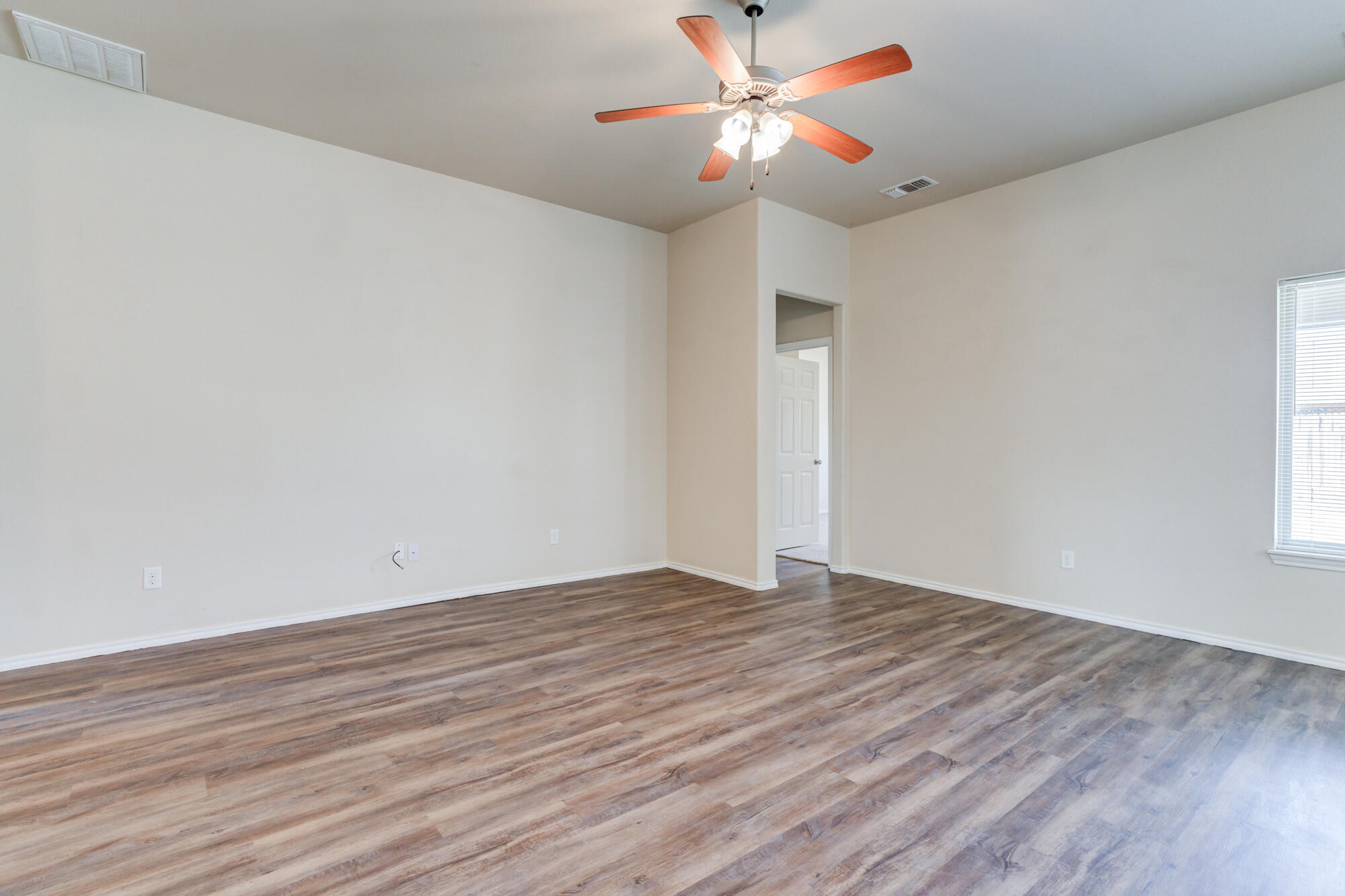 7518 87th Street Lubbock, TX 79424 - Photo 9 of 36 a view of an empty room with window and wooden floor
