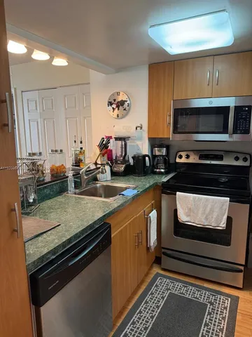 a kitchen with stainless steel appliances a stove a sink and a microwave