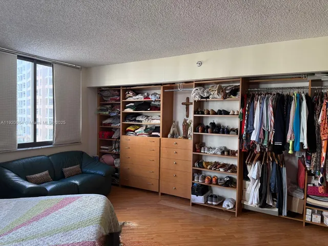 a view of walk in closet with clothes and shoes