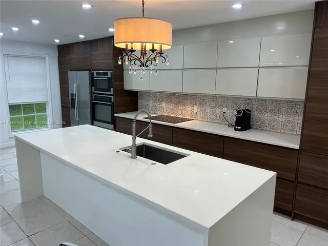 a kitchen with stainless steel appliances a sink a refrigerator and a stove
