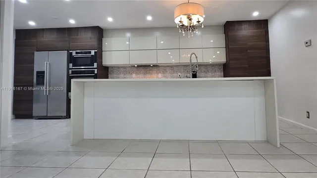 a kitchen with a refrigerator and a sink