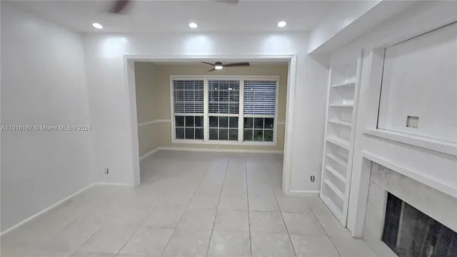 a view of an empty room with a fireplace and a window