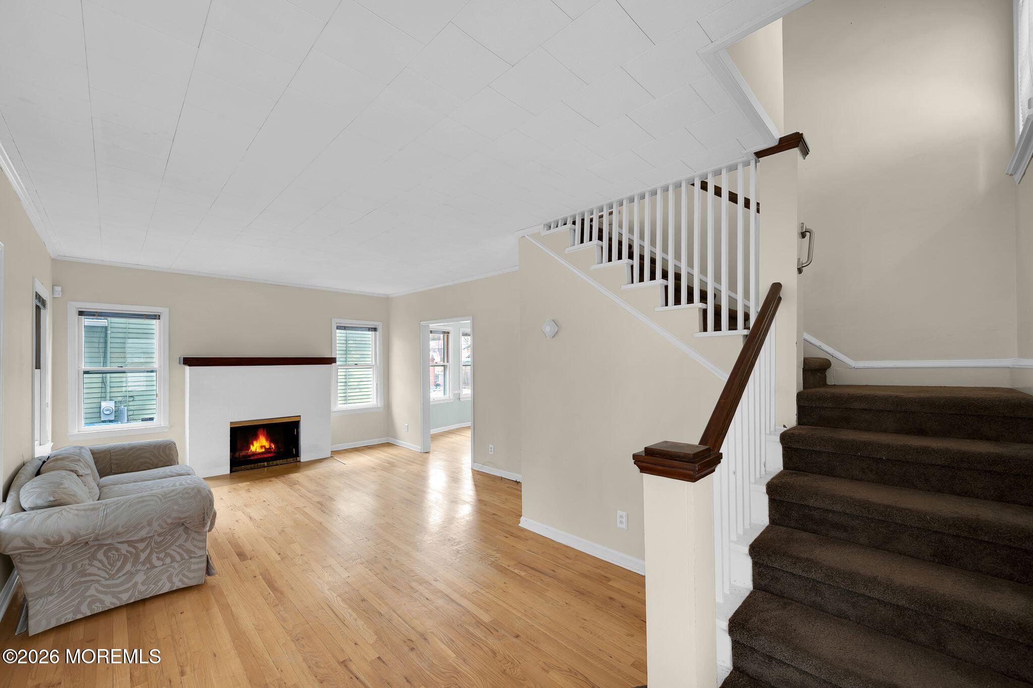 1405 Wanamassa Road Asbury Park, NJ 07712 - Photo 7 of 42 a view of a livingroom with wooden floor and a fireplace