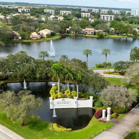 an aerial view of a house with swimming pool a yard and lake view