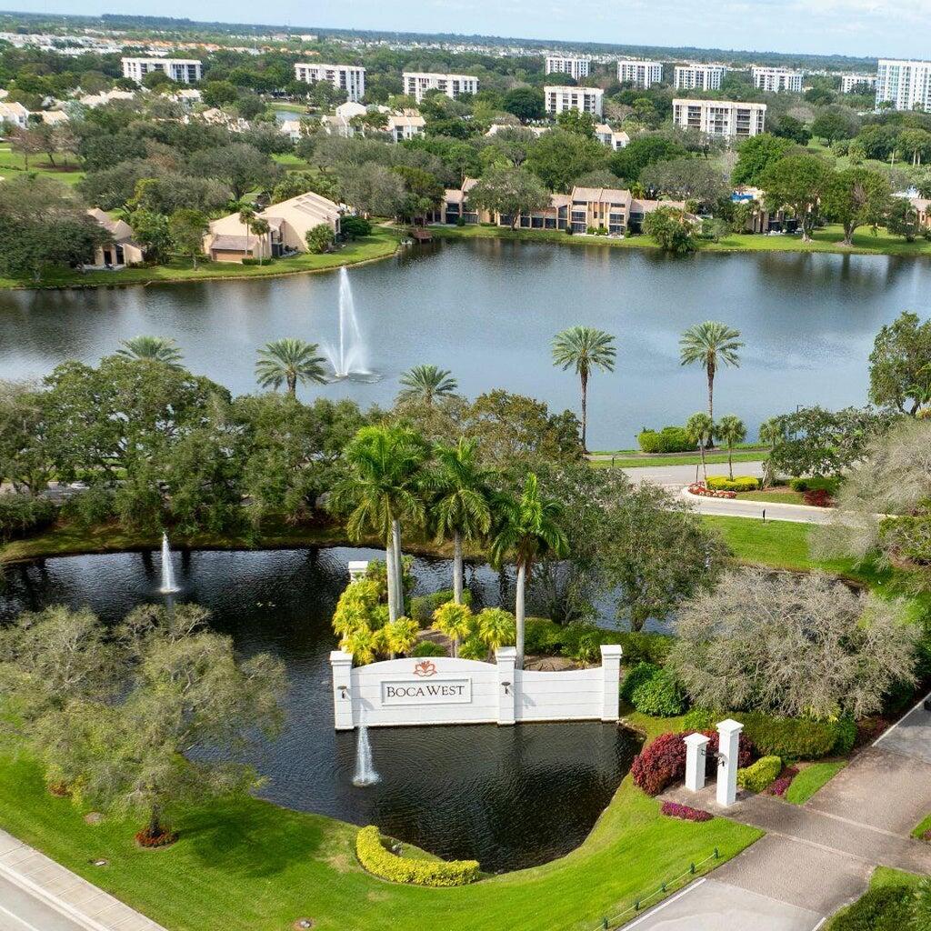 an aerial view of a house with swimming pool a yard and lake view
