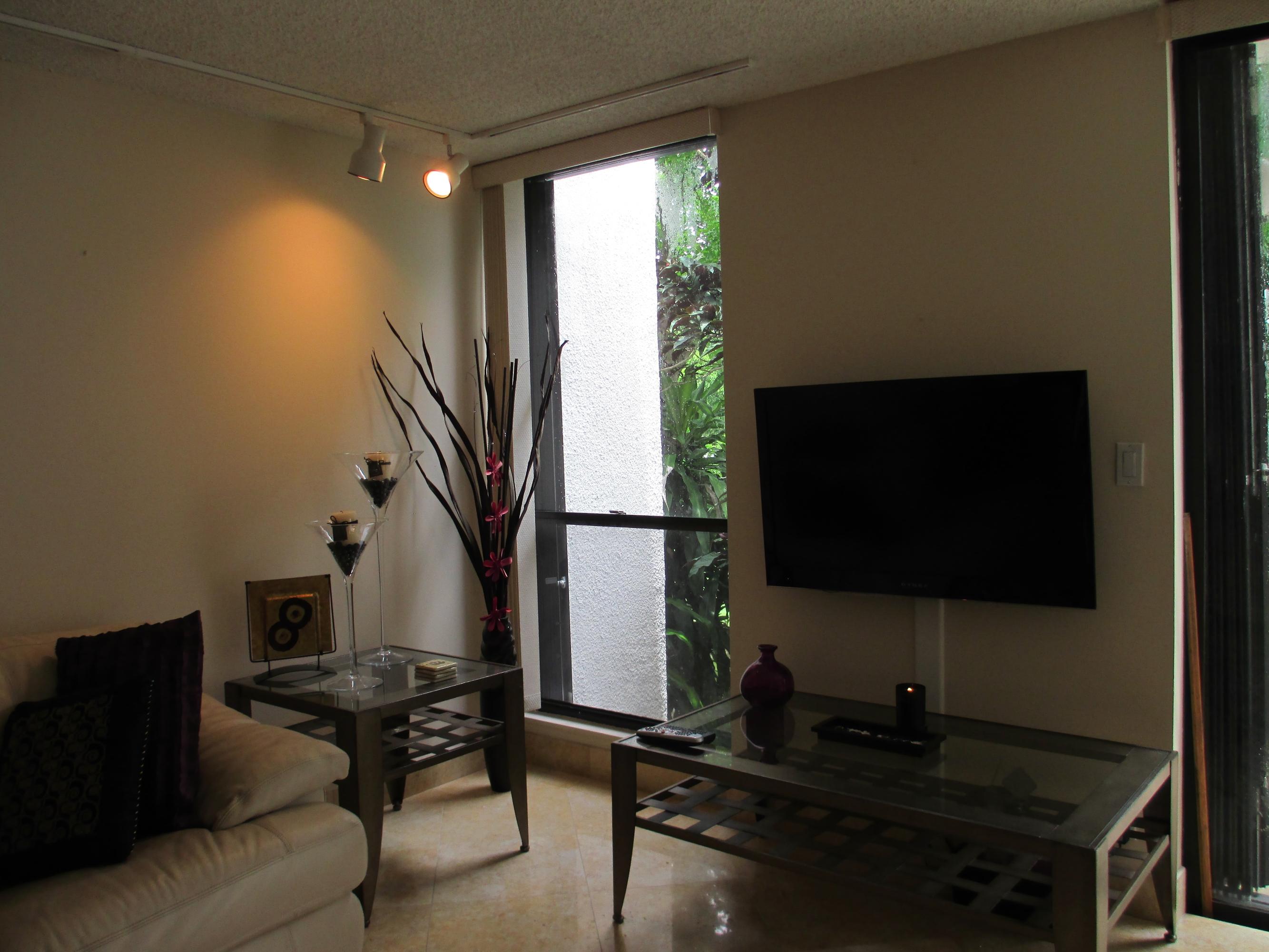 1405 Bridgewood Drive, Unit 1405 Boca Raton, FL 33434 - Photo 20 of 54 a living room with furniture and a flat screen tv