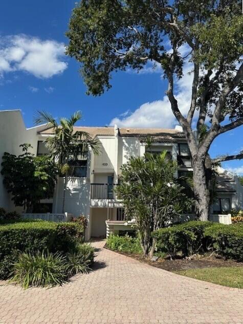 1405 Bridgewood Drive, Unit 1405 Boca Raton, FL 33434 - Photo 2 of 54 a front view of a house with a yard and outdoor seating