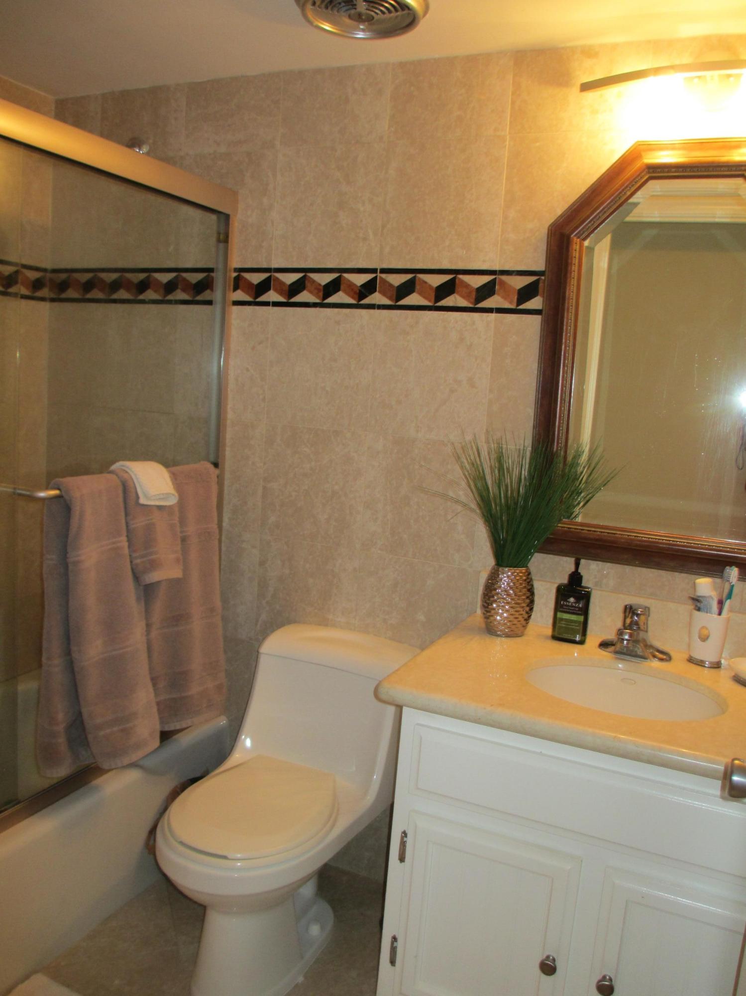 1405 Bridgewood Drive, Unit 1405 Boca Raton, FL 33434 - Photo 22 of 45 a bathroom with a sink toilet and mirror