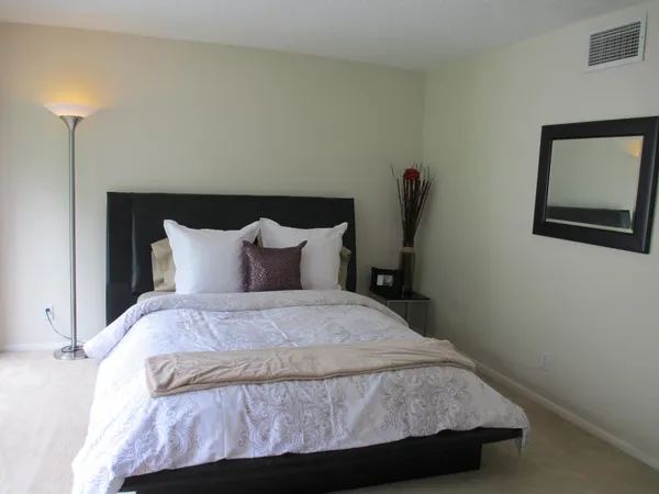 a large bed sitting in a bedroom next to a window