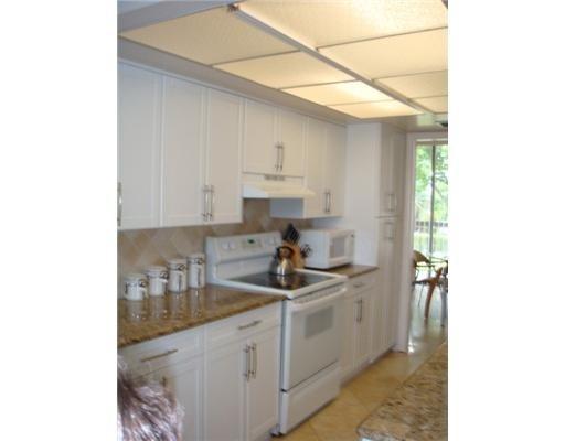 1405 Bridgewood Drive, Unit 1405 Boca Raton, FL 33434 - Photo 29 of 54 a kitchen with a sink cabinets and window