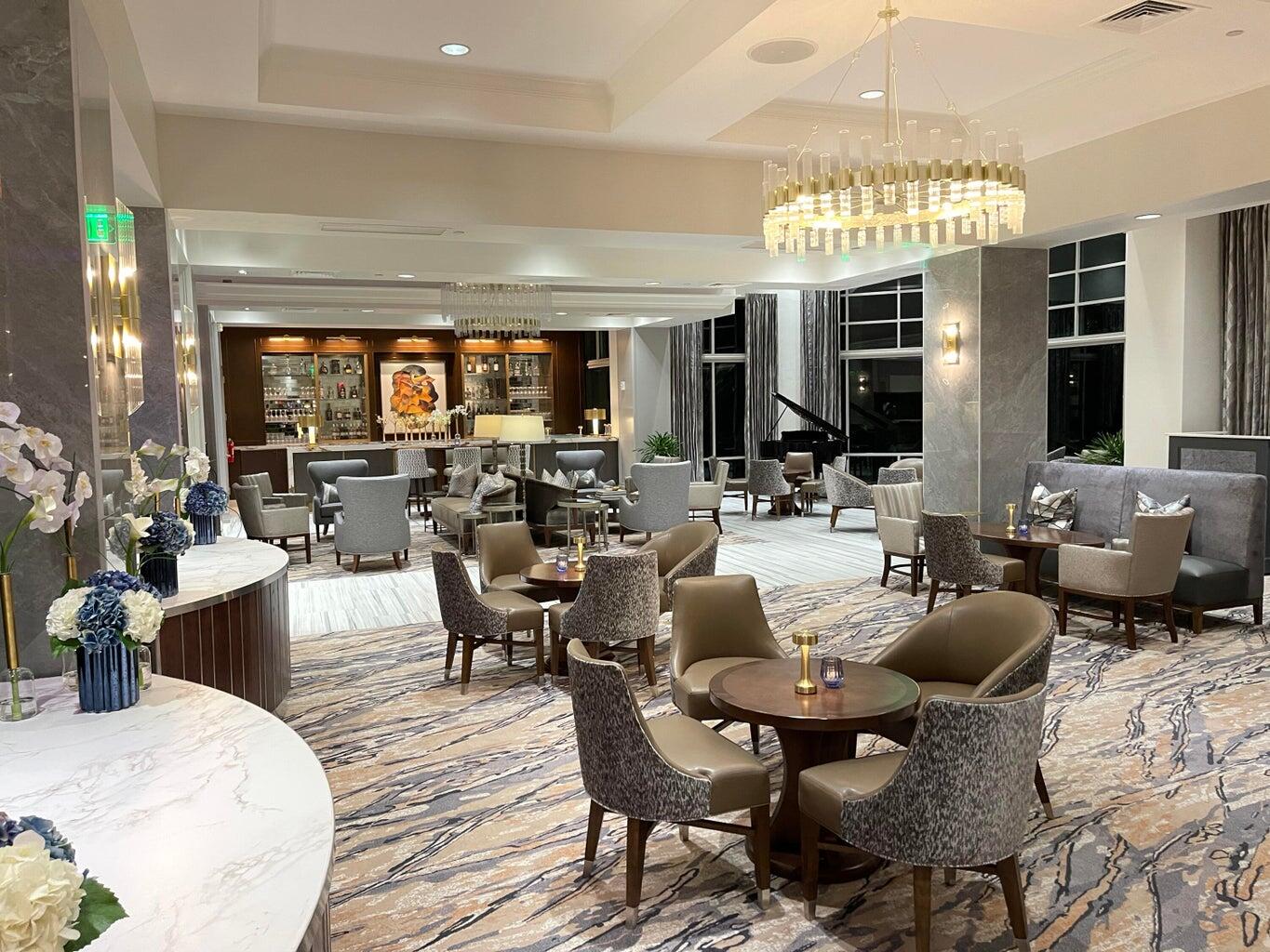 1405 Bridgewood Drive, Unit 1405 Boca Raton, FL 33434 - Photo 37 of 54 a view of a dining room with furniture a chandelier and wooden floor