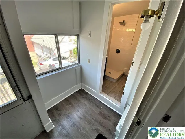 an entryway with wooden floor and windows