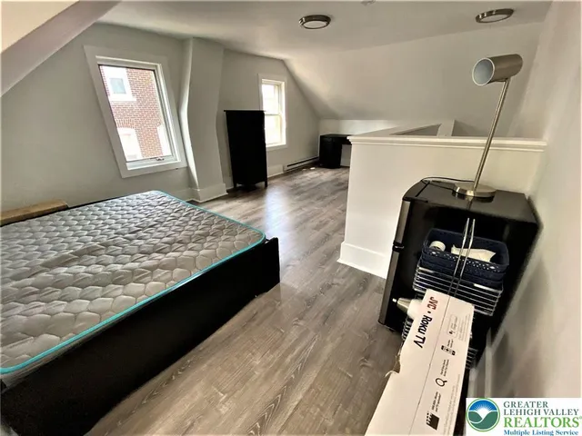 a living room with a bed and a television