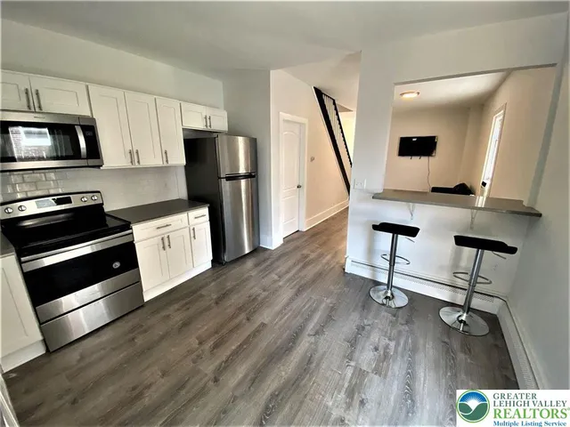a view of kitchen with sink microwave and refrigerator