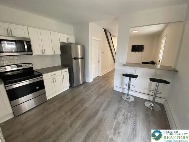 a view of kitchen with sink microwave and refrigerator