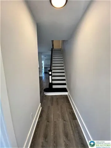 a view of a hallway with wooden floor and entryway
