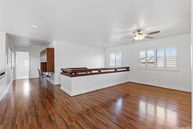 a living room with stainless steel appliances kitchen island hard wood floors and fireplace