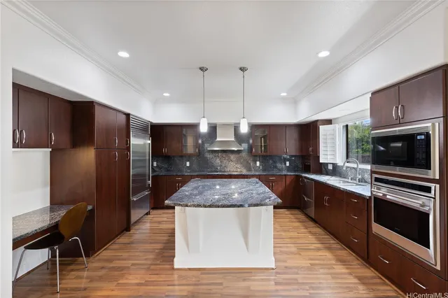 a large kitchen with stainless steel appliances granite countertop a stove a sink dishwasher a refrigerator and a microwave oven with wooden floor