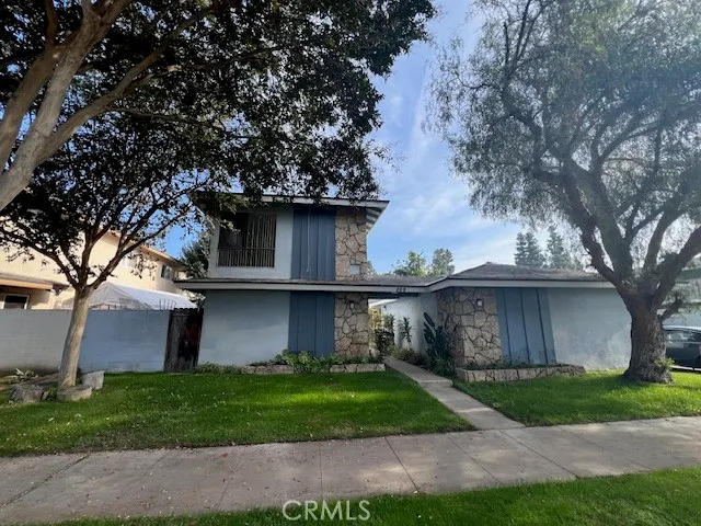 a view of a yard in front of a house with large trees