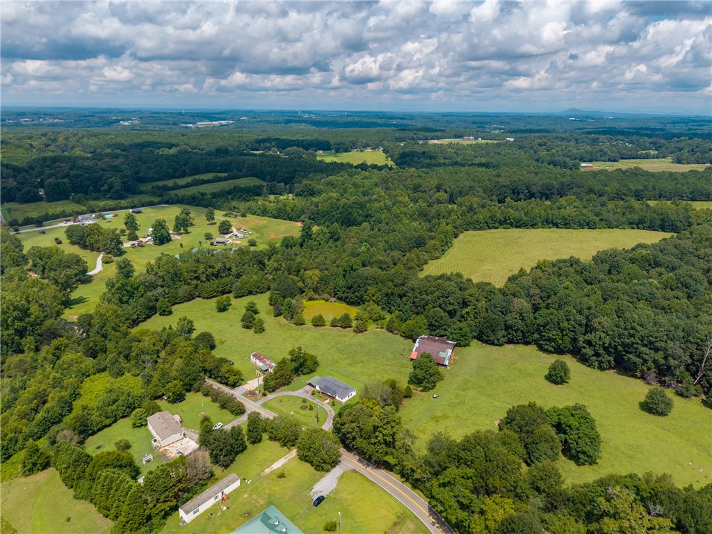 503 Mulliken Road Central, SC 29630 - Photo 38 of 50 Vast green acreage unfolds under a partly cloudy sky, offering serene rural living.