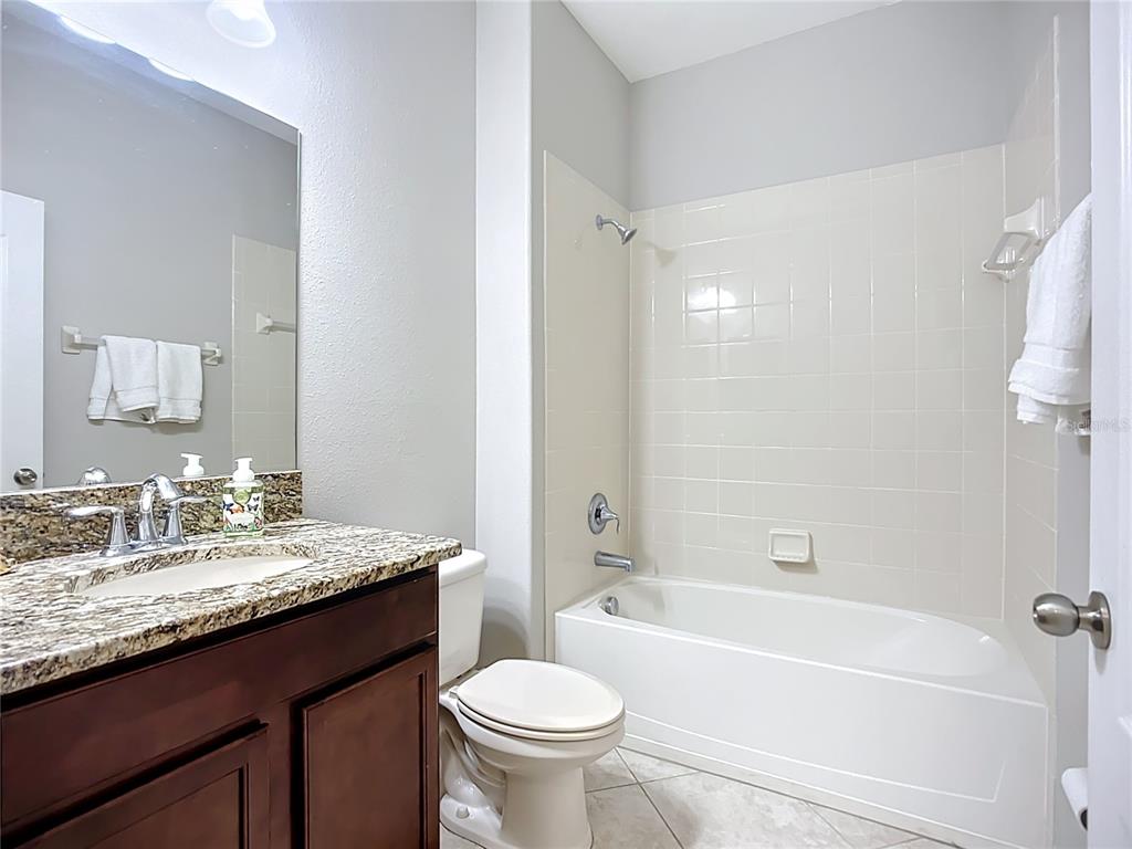 14240 Blue Dasher Drive Riverview, FL 33569 - Photo 17 of 25 a bathroom with a granite countertop sink a toilet a mirror and a bathtub