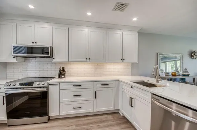 a kitchen with granite countertop a stove sink and cabinets