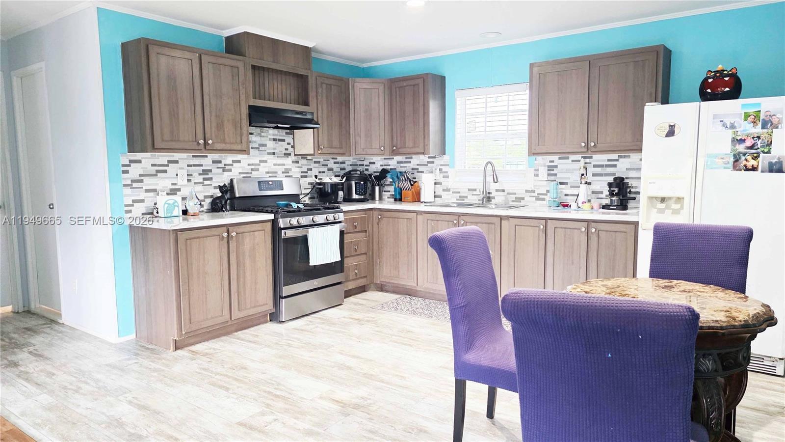 612 Hunting Clb Avenue Clewiston, FL 33440 - Photo 12 of 36 a kitchen with granite countertop wooden cabinets and stainless steel appliances