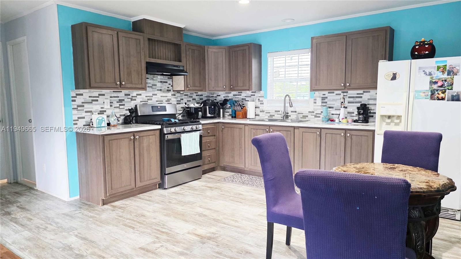 612 Hunting Clb Avenue Clewiston, FL 33440 - Photo 15 of 36 a kitchen with granite countertop wooden cabinets and stainless steel appliances
