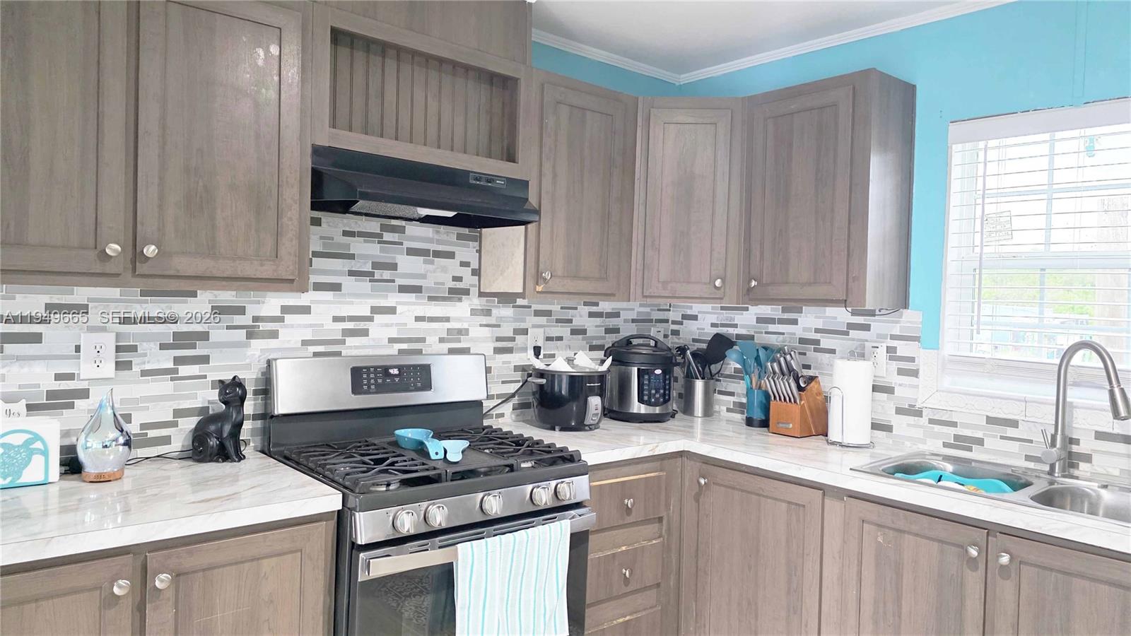 612 Hunting Clb Avenue Clewiston, FL 33440 - Photo 17 of 36 a kitchen with stainless steel appliances granite countertop a sink stove and cabinets