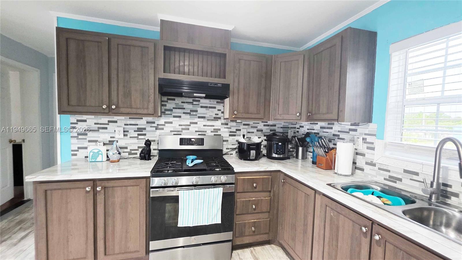 612 Hunting Clb Avenue Clewiston, FL 33440 - Photo 21 of 36 a kitchen with stainless steel appliances a stove a sink a cabinets and a window