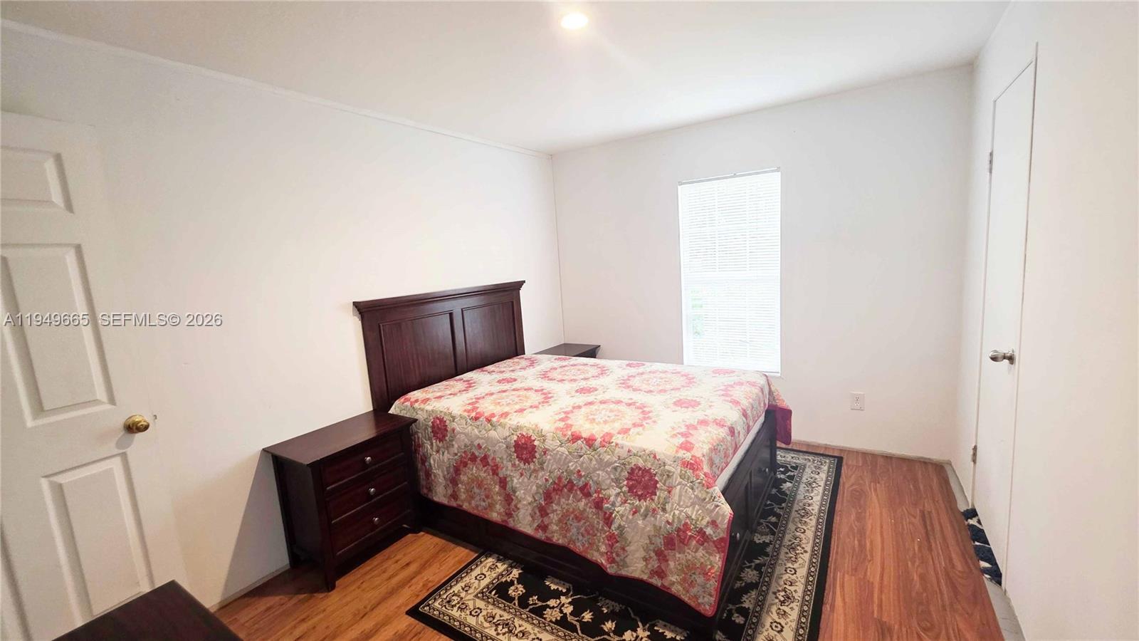 612 Hunting Clb Avenue Clewiston, FL 33440 - Photo 31 of 36 a bedroom with a bed and wooden floor