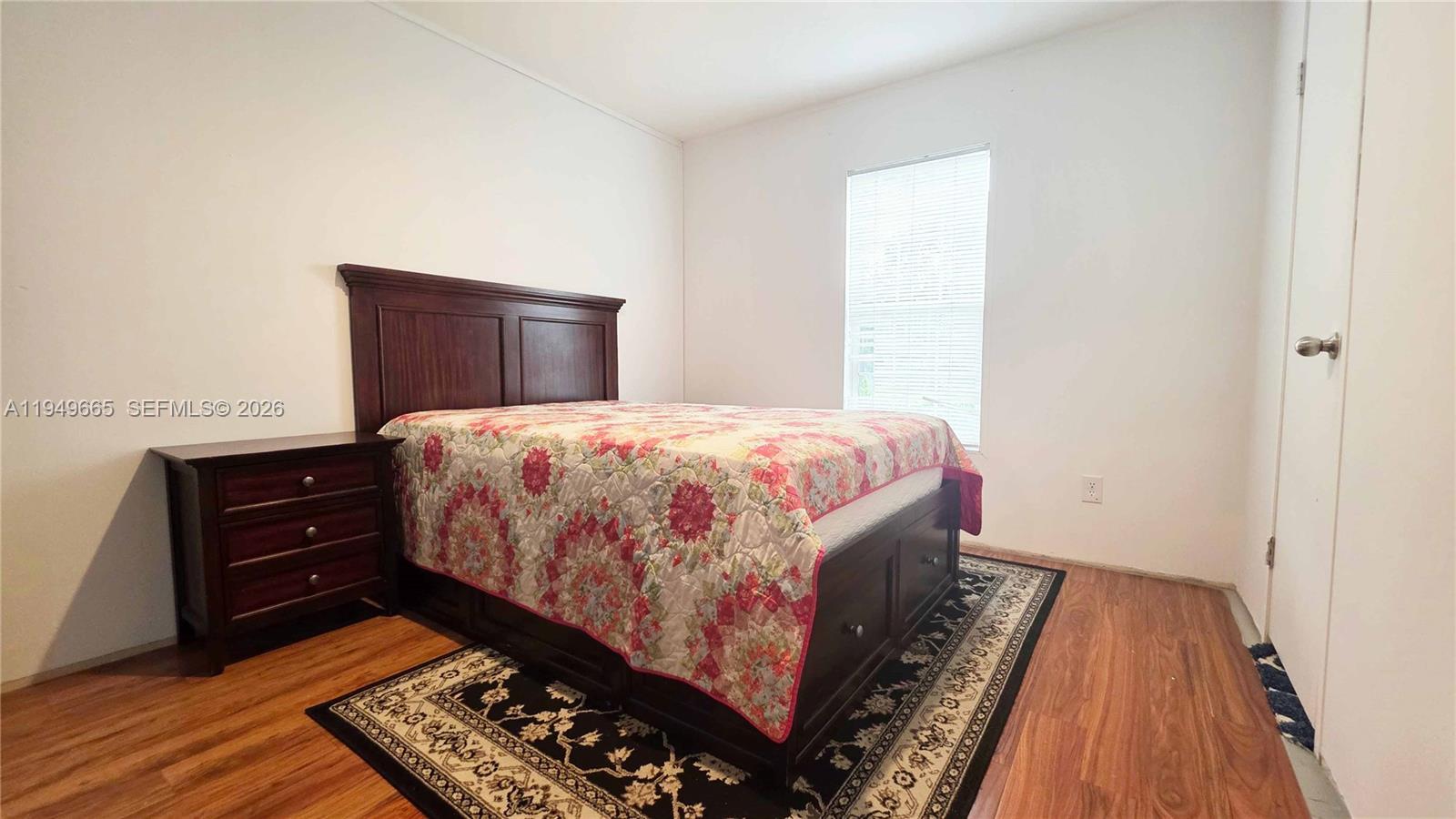 612 Hunting Clb Avenue Clewiston, FL 33440 - Photo 32 of 36 a bedroom with a bed and wooden floor