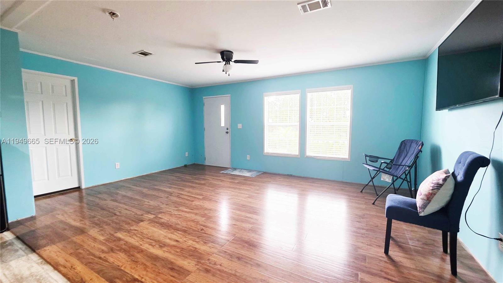 612 Hunting Clb Avenue Clewiston, FL 33440 - Photo 8 of 36 a view of empty room with wooden floor and fan