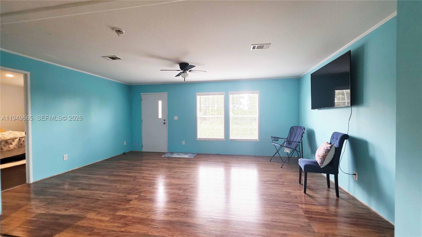 612 Hunting Clb Avenue Clewiston, FL 33440 - Photo 10 of 36 a living room with furniture and a flat screen tv
