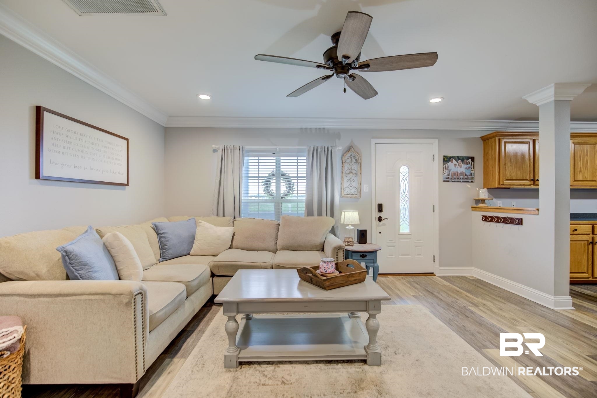 18732 Fairground Road Robertsdale, AL 36567 - Photo 10 of 46 Living room with decorative columns, crown molding, light wood-type flooring, and ceiling fan