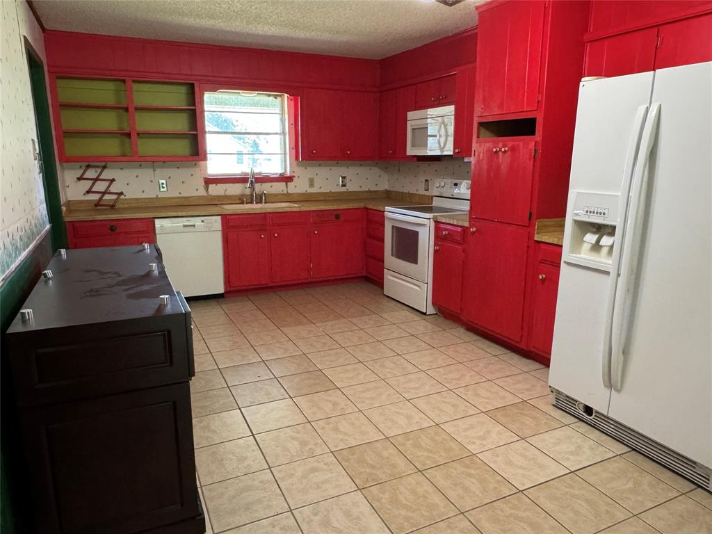 415 Meadowlark Trail Springtown, TX 76082 - Photo 7 of 40 a kitchen with stainless steel appliances a refrigerator sink and cabinets