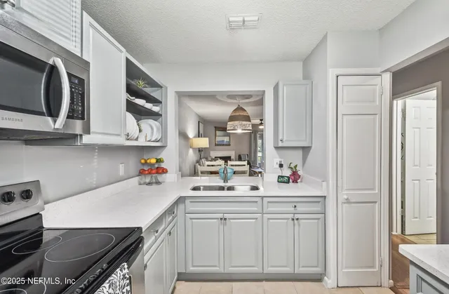 a kitchen with stainless steel appliances a sink stove and cabinets