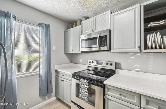 a kitchen with stainless steel appliances a stove a microwave and cabinets