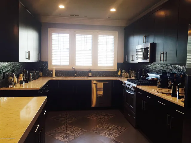 a kitchen with granite countertop a stove a sink and a refrigerator