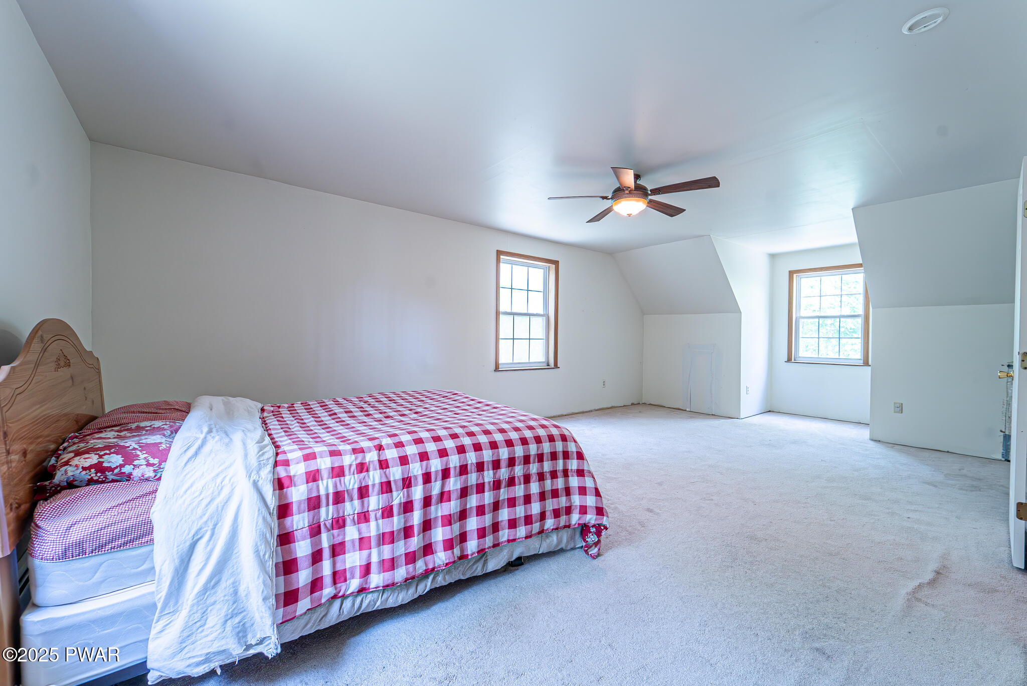 101 Maple Ridge Road Milford, PA 18337 - Photo 33 of 39 a bedroom with a bed and a ceiling fan