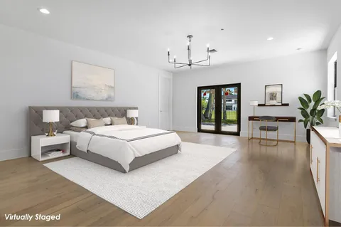 a bedroom with a large bed and a chandelier