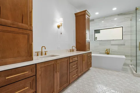 a bathroom with a double vanity sink a mirror and a bathtub
