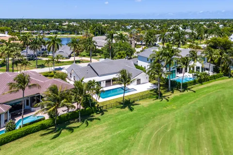 an aerial view of residential houses with outdoor space and trees
