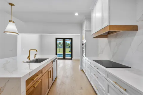 a kitchen with stainless steel appliances granite countertop a sink and a wooden floor
